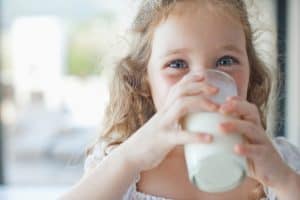 niña tomando vaso de leche