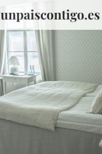white bed linen near white wooden nightstand
