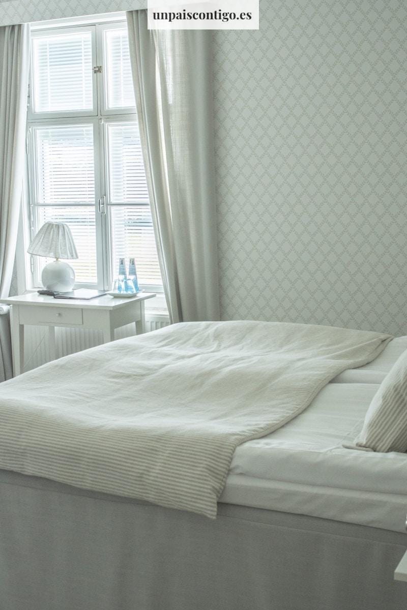 white bed linen near white wooden nightstand