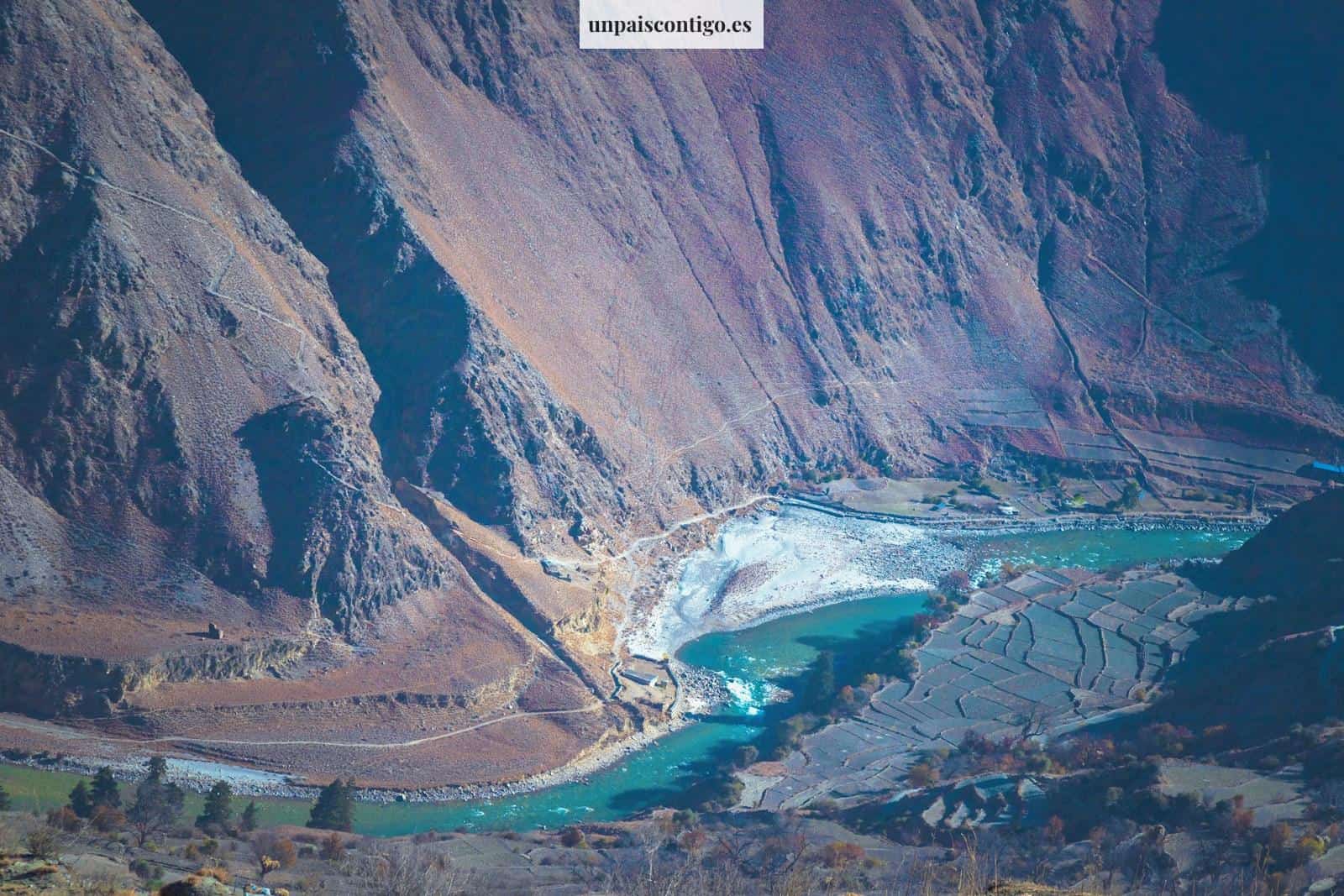 a river running through a valley surrounded by mountains