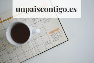 white ceramic mug with coffee on top of a planner