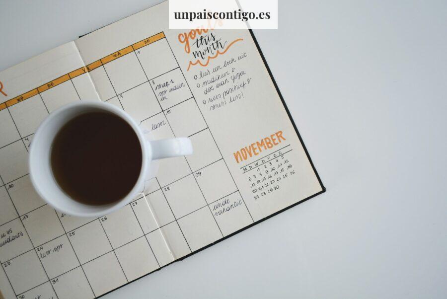 white ceramic mug with coffee on top of a planner