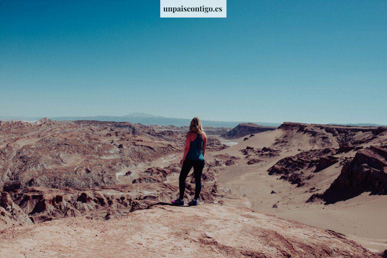 woman on black dress atop of canyon looking at the mountainous terrain during daytime