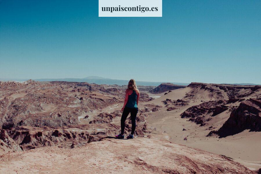 woman on black dress atop of canyon looking at the mountainous terrain during daytime