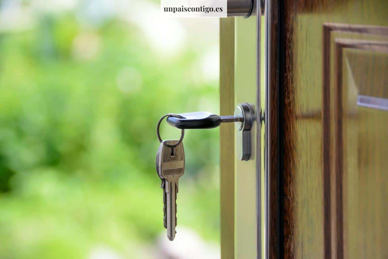 Key inserted in door lock against a blurred green background, symbolizing security and real estate.