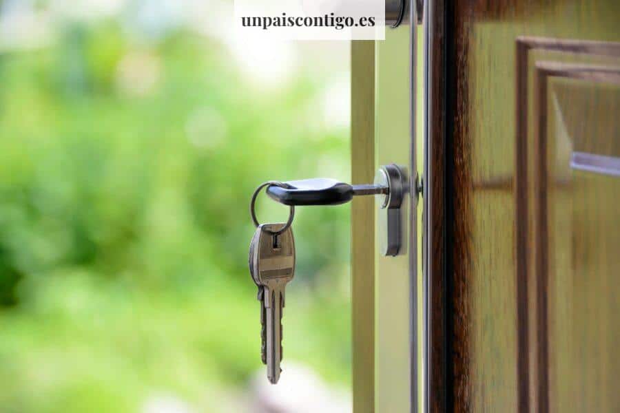 Key inserted in door lock against a blurred green background, symbolizing security and real estate.