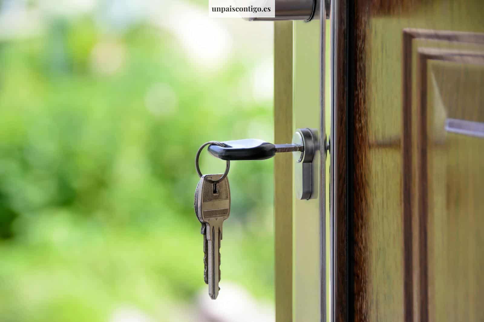 Key inserted in door lock against a blurred green background, symbolizing security and real estate.