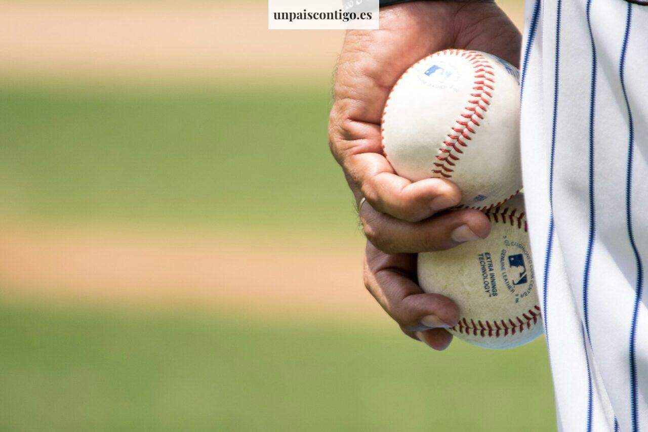 person holding two baseballs