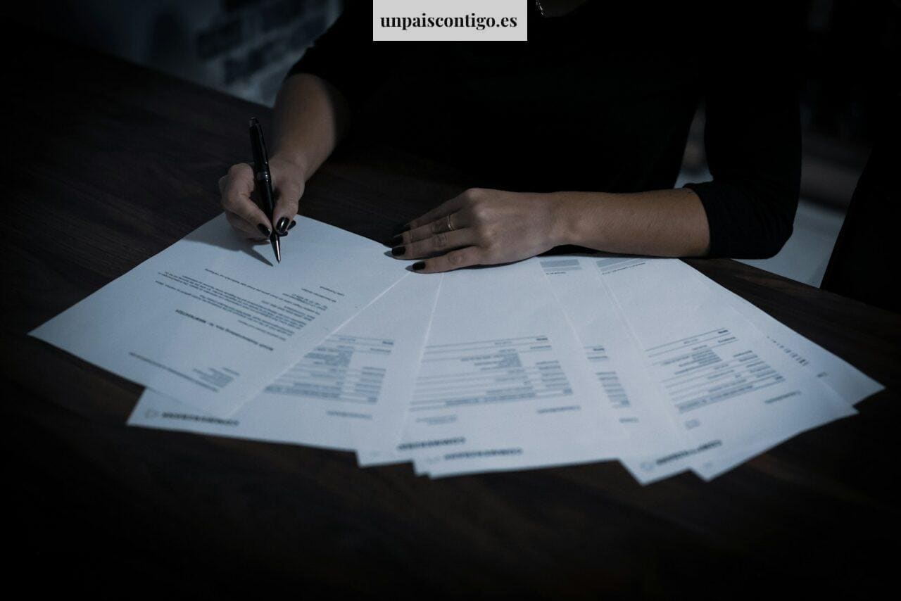 a woman sitting at a table with lots of papers