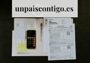 black Android smartphone near ballpoint pen, tax withholding certificate on top of white folder