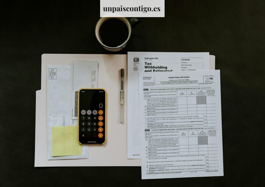 black Android smartphone near ballpoint pen, tax withholding certificate on top of white folder